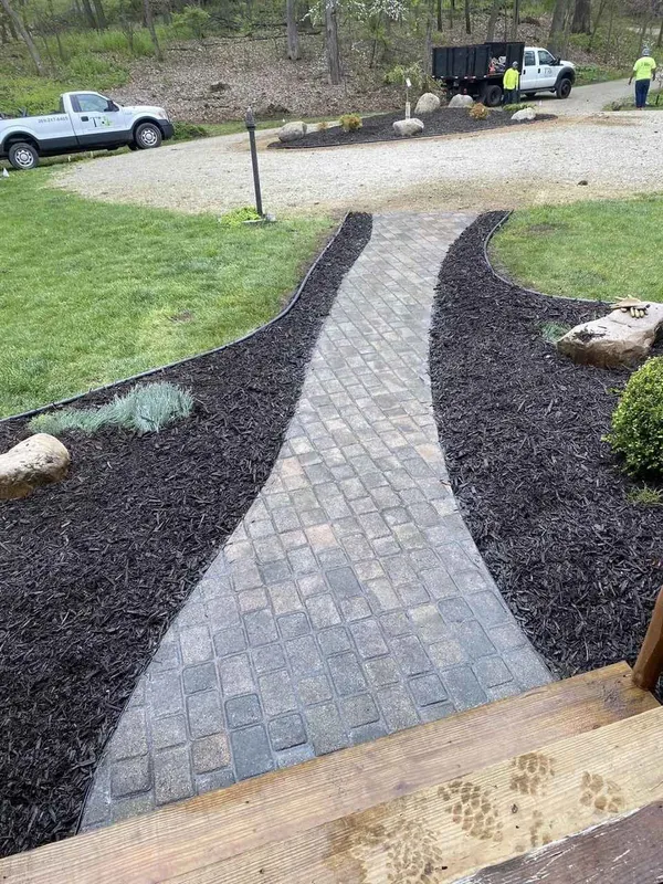Patio connected to walkway and landscaped yard