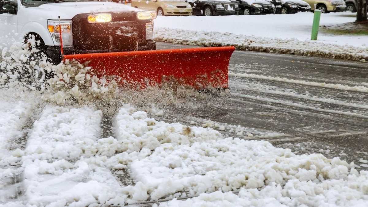 Snow plowing equipment clearing a parking lot